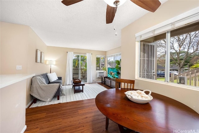 interior space featuring a ceiling fan, cooling unit, wood finished floors, and a textured ceiling