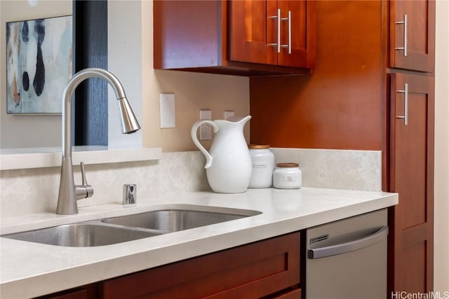 kitchen with a sink, stainless steel dishwasher, and light countertops