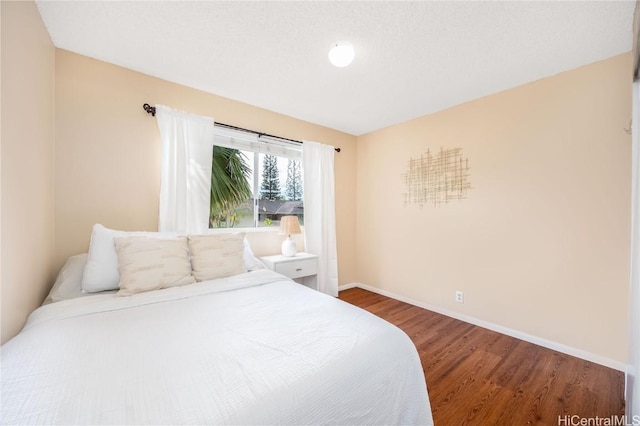 bedroom featuring baseboards and wood finished floors