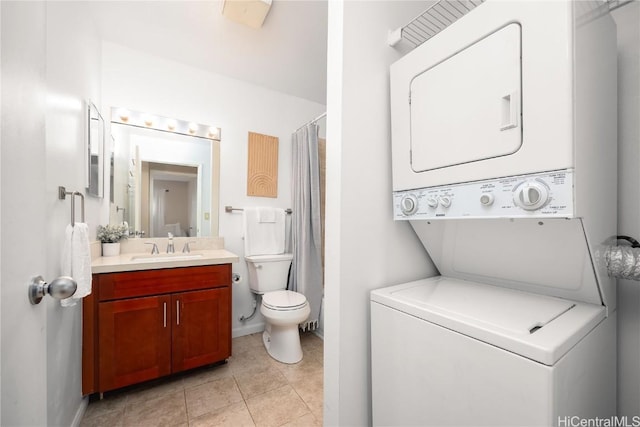 bathroom with a shower with curtain, toilet, stacked washer and clothes dryer, tile patterned flooring, and vanity