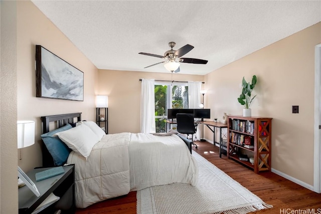 bedroom with ceiling fan, baseboards, a textured ceiling, and wood finished floors