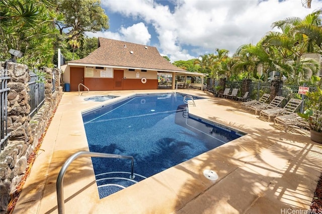 pool featuring a patio area, a hot tub, and fence