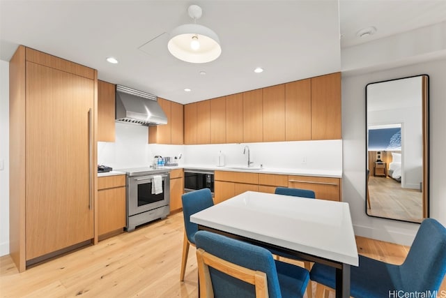 kitchen featuring light wood finished floors, stainless steel electric stove, recessed lighting, wall chimney exhaust hood, and a sink