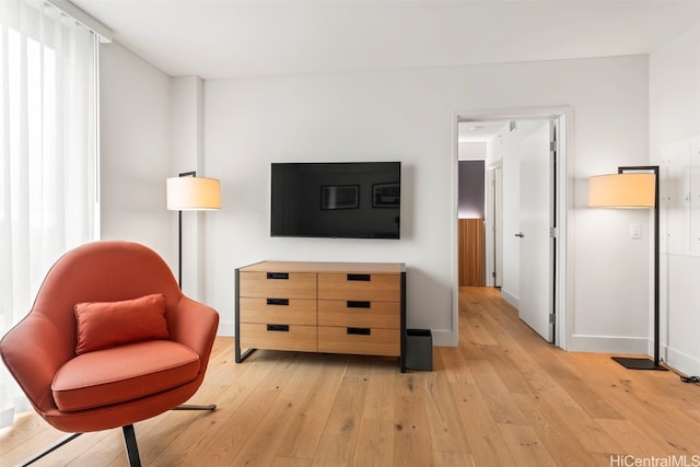 living area featuring light wood-type flooring and baseboards