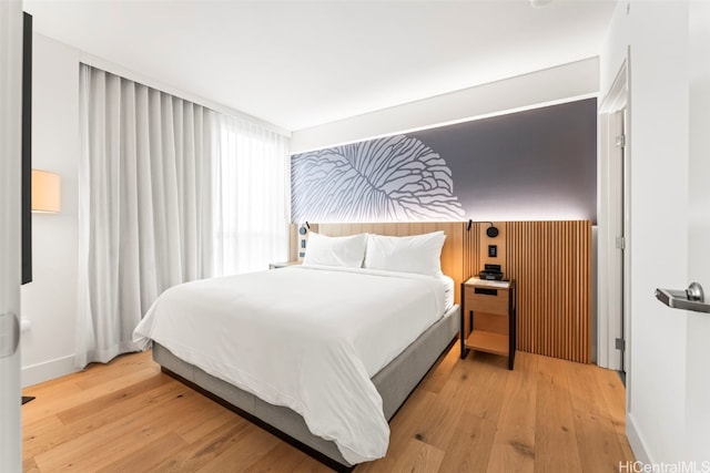 bedroom with baseboards and wood finished floors