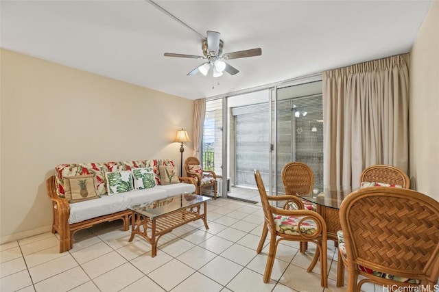 living area with light tile patterned floors, baseboards, and ceiling fan