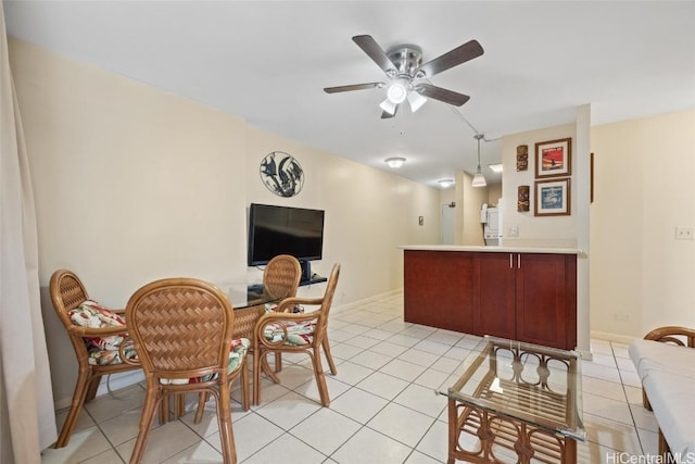 dining area featuring light tile patterned flooring, baseboards, and ceiling fan