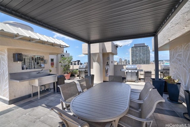 view of patio featuring a city view, outdoor dining area, and grilling area