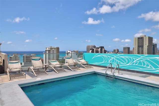 view of pool with a view of city and a water view