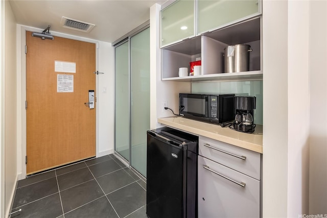 410 Atkinson Dr Unit 1609, Honolulu, HI 96814 - bar area featuring fridge, black microwave, and dark tile patterned floors