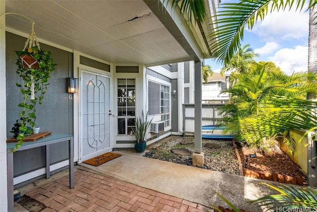 view of exterior entry featuring stucco siding and cooling unit