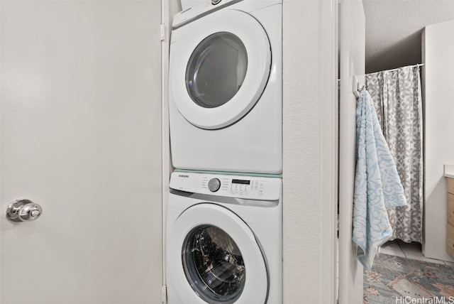 washroom featuring tile patterned flooring and stacked washing maching and dryer