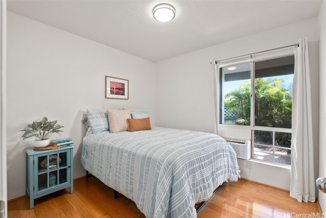 bedroom with multiple windows and wood finished floors