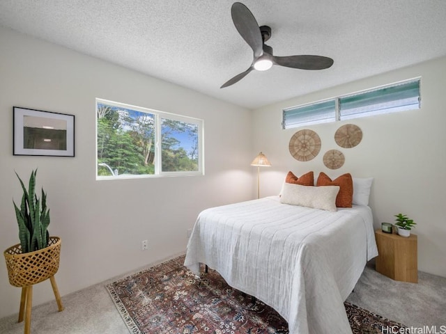 carpeted bedroom with a textured ceiling and ceiling fan