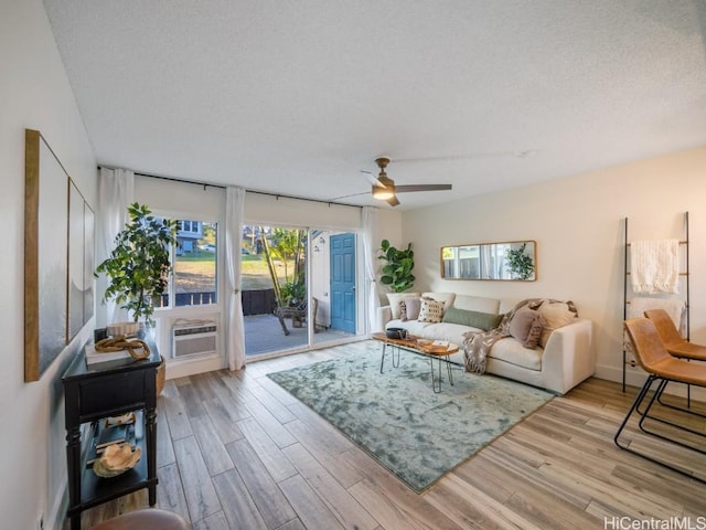 living area featuring a textured ceiling, wood finished floors, and a ceiling fan