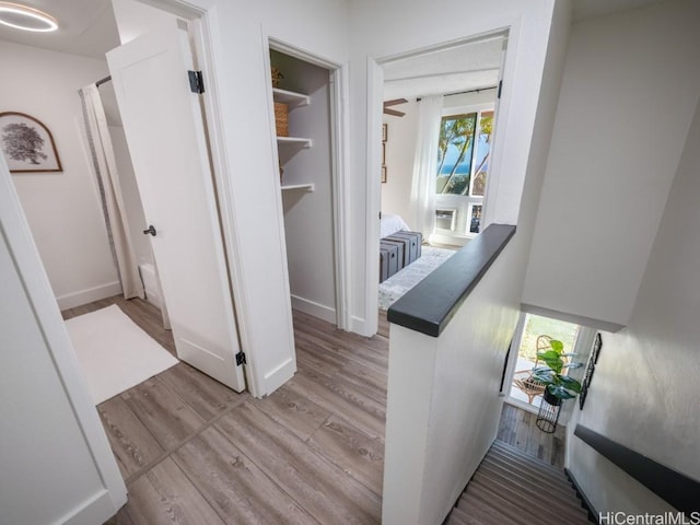 hall featuring baseboards and light wood-type flooring