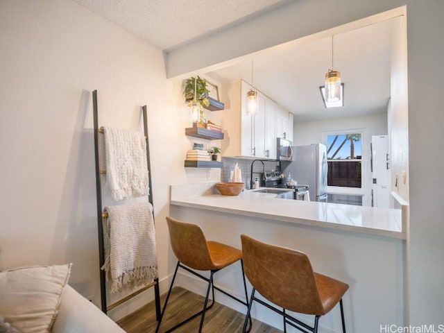 kitchen featuring decorative backsplash, stainless steel appliances, light countertops, and wood finished floors