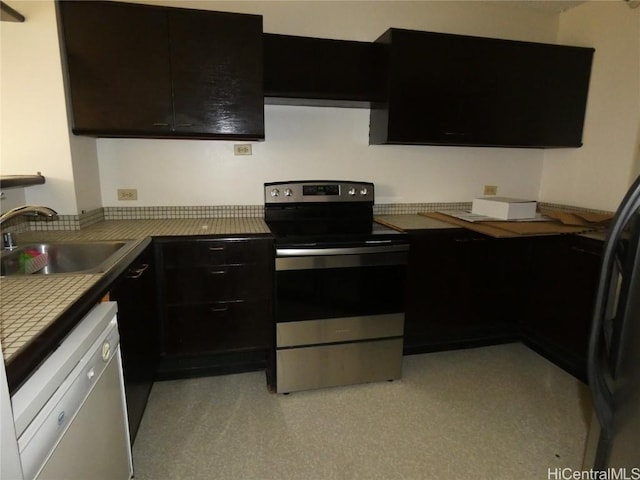 kitchen featuring dark cabinetry, dishwashing machine, electric stove, and a sink