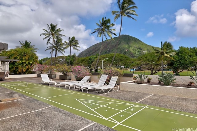 view of property's community with a mountain view and shuffleboard