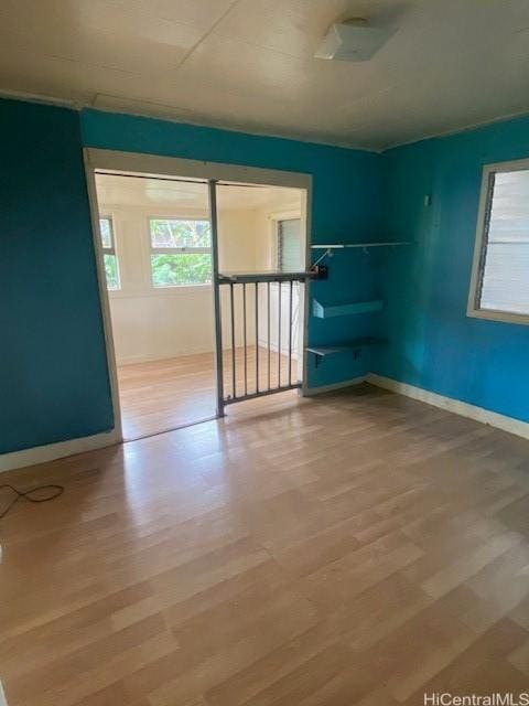 unfurnished room with baseboards and wood finished floors