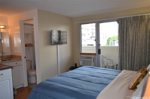 bedroom with a sink, cooling unit, and wood finished floors