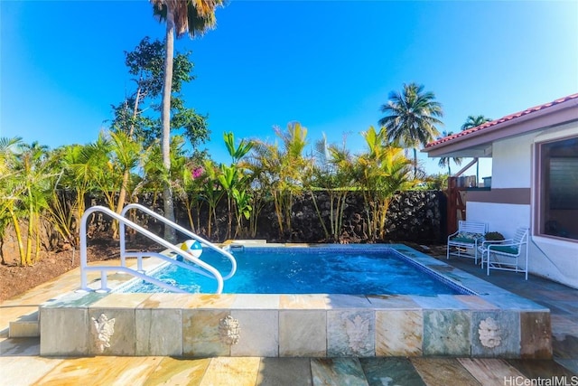 outdoor pool with a fenced backyard and a patio