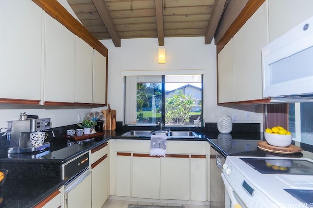 kitchen featuring white appliances, white cabinetry, beam ceiling, and a sink