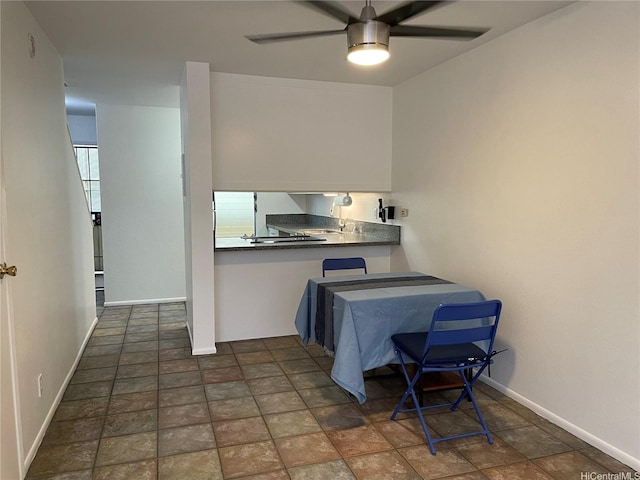 46-232 Kahuhipa St Unit B207, Kaneohe, HI 96744 - kitchen with ceiling fan, baseboards, dark countertops, and stone finish floors