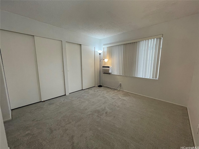 46-232 Kahuhipa St Unit B207, Kaneohe, HI 96744 - unfurnished bedroom with two closets, carpet, a wall unit AC, and a textured ceiling