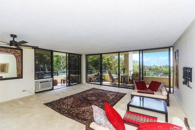 living area featuring ceiling fan, a wall of windows, and a wall unit AC