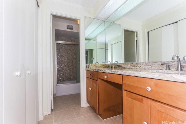 full bathroom with a sink, combined bath / shower with glass door, crown molding, tile patterned flooring, and double vanity