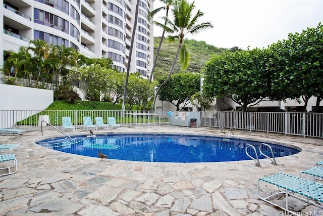 pool with a patio area and fence