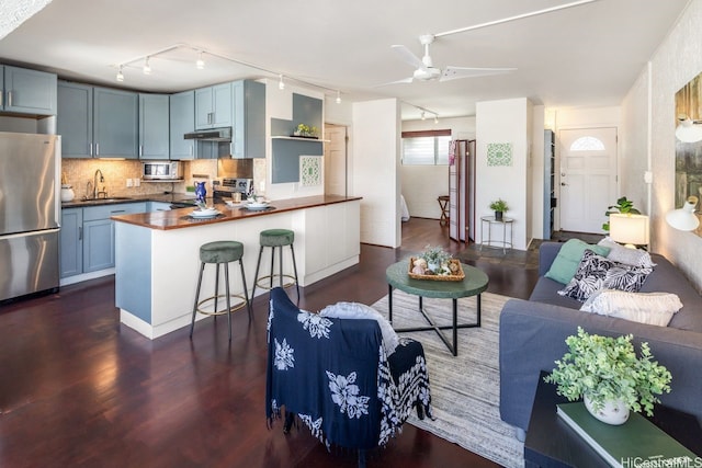 3061 Pualei Cir Unit 303, Honolulu, HI 96815 - kitchen with stainless steel appliances, under cabinet range hood, a sink, rail lighting, and a peninsula