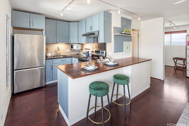 3061 Pualei Cir Unit 303, Honolulu, HI 96815 - kitchen featuring appliances with stainless steel finishes, track lighting, under cabinet range hood, and open shelves