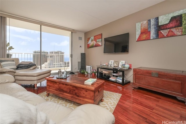 living room featuring wood finished floors, visible vents, and expansive windows