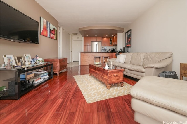 living room with dark wood-style floors and arched walkways