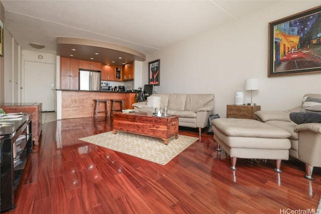 living area featuring arched walkways and wood finished floors