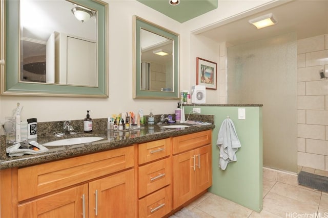 bathroom featuring tile patterned floors, a tile shower, and a sink