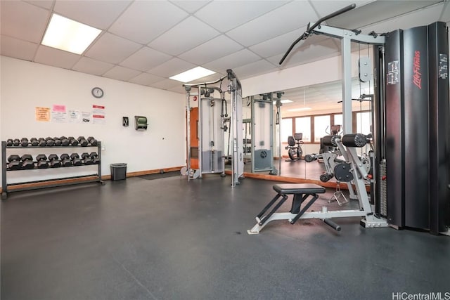 workout area with baseboards and a drop ceiling