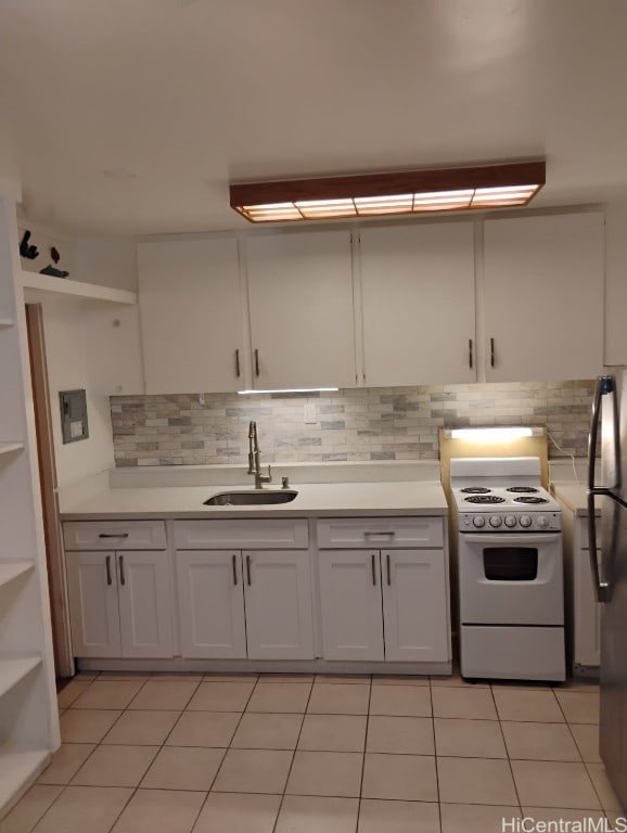 kitchen featuring a sink, white electric stove, light tile patterned flooring, light countertops, and decorative backsplash