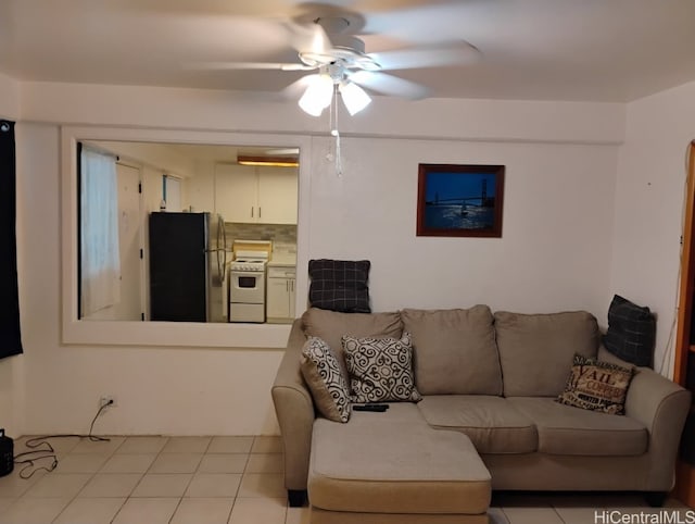 living area with light tile patterned floors and ceiling fan