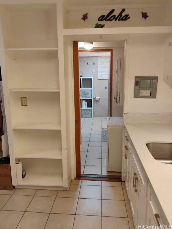 kitchen featuring light tile patterned flooring, white cabinets, light countertops, and open shelves