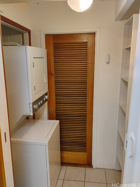 washroom featuring light tile patterned floors and stacked washer and dryer