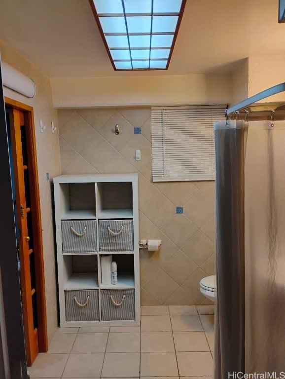 bathroom with tile patterned flooring, tile walls, toilet, and a shower with curtain