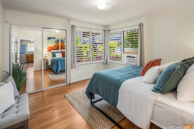 bedroom featuring cooling unit, a closet, and light wood finished floors