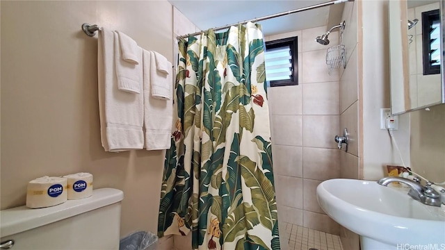 full bath featuring toilet, a shower with curtain, and a sink