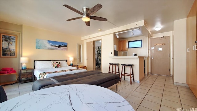 bedroom with a spacious closet, baseboards, light tile patterned floors, a closet, and a ceiling fan