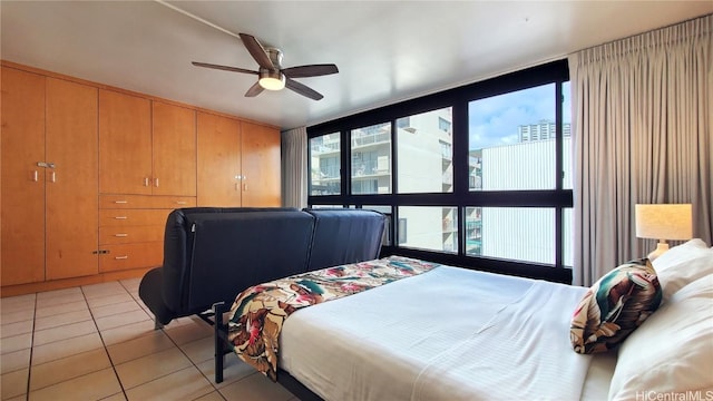 bedroom with a ceiling fan, floor to ceiling windows, multiple windows, and light tile patterned flooring