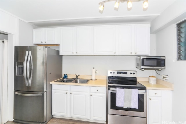 kitchen featuring a sink, appliances with stainless steel finishes, white cabinets, and light countertops