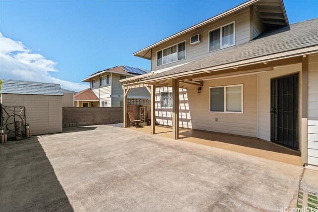48 Kuuhale Pl, Kahului, HI 96732 - back of property with fence, roof with shingles, a patio area, a storage unit, and an outbuilding